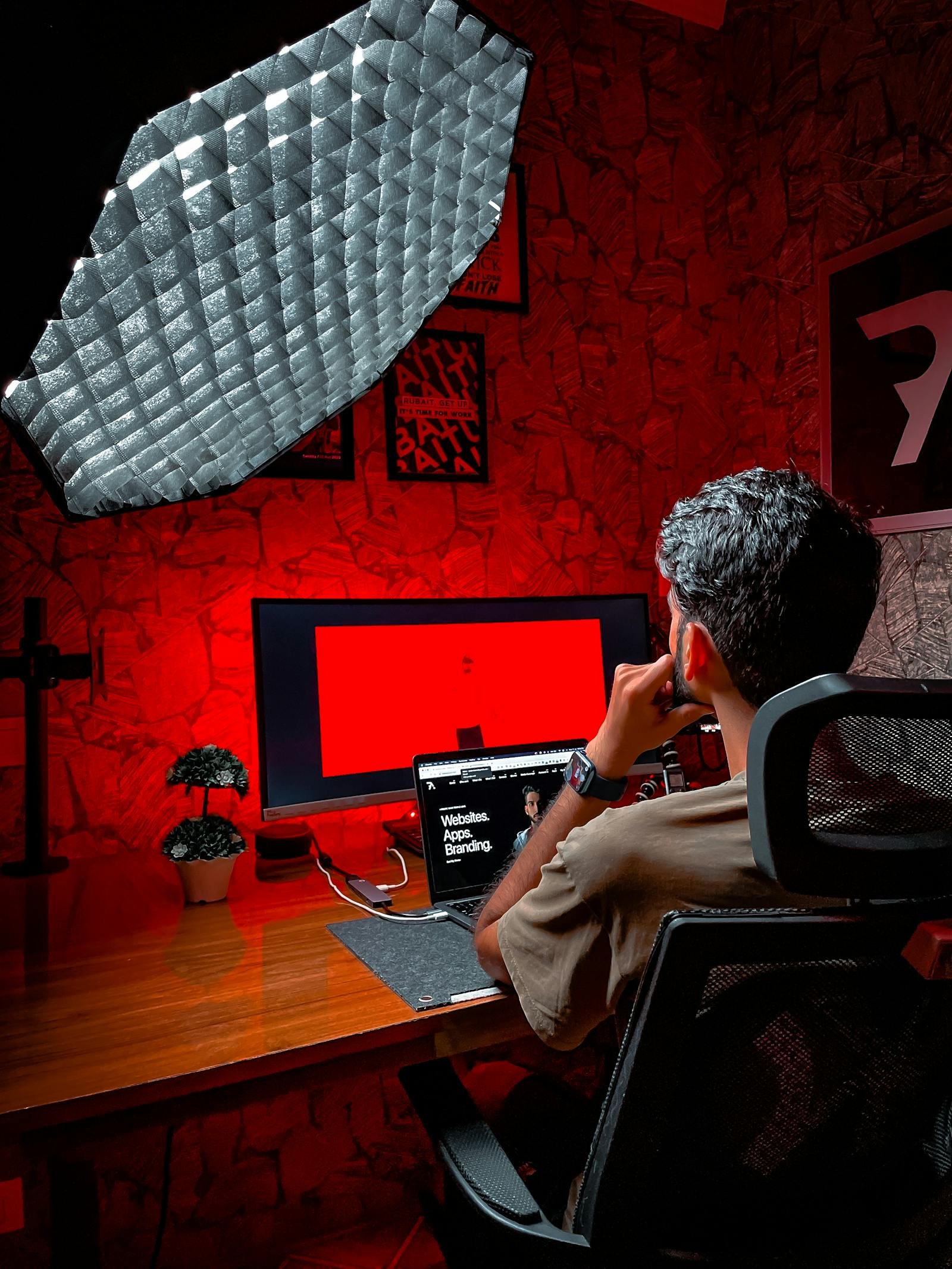 Freelancer working on a laptop in a dim studio with red ambient lighting illustrating Freelancing as a Creator: A Proven Strategy