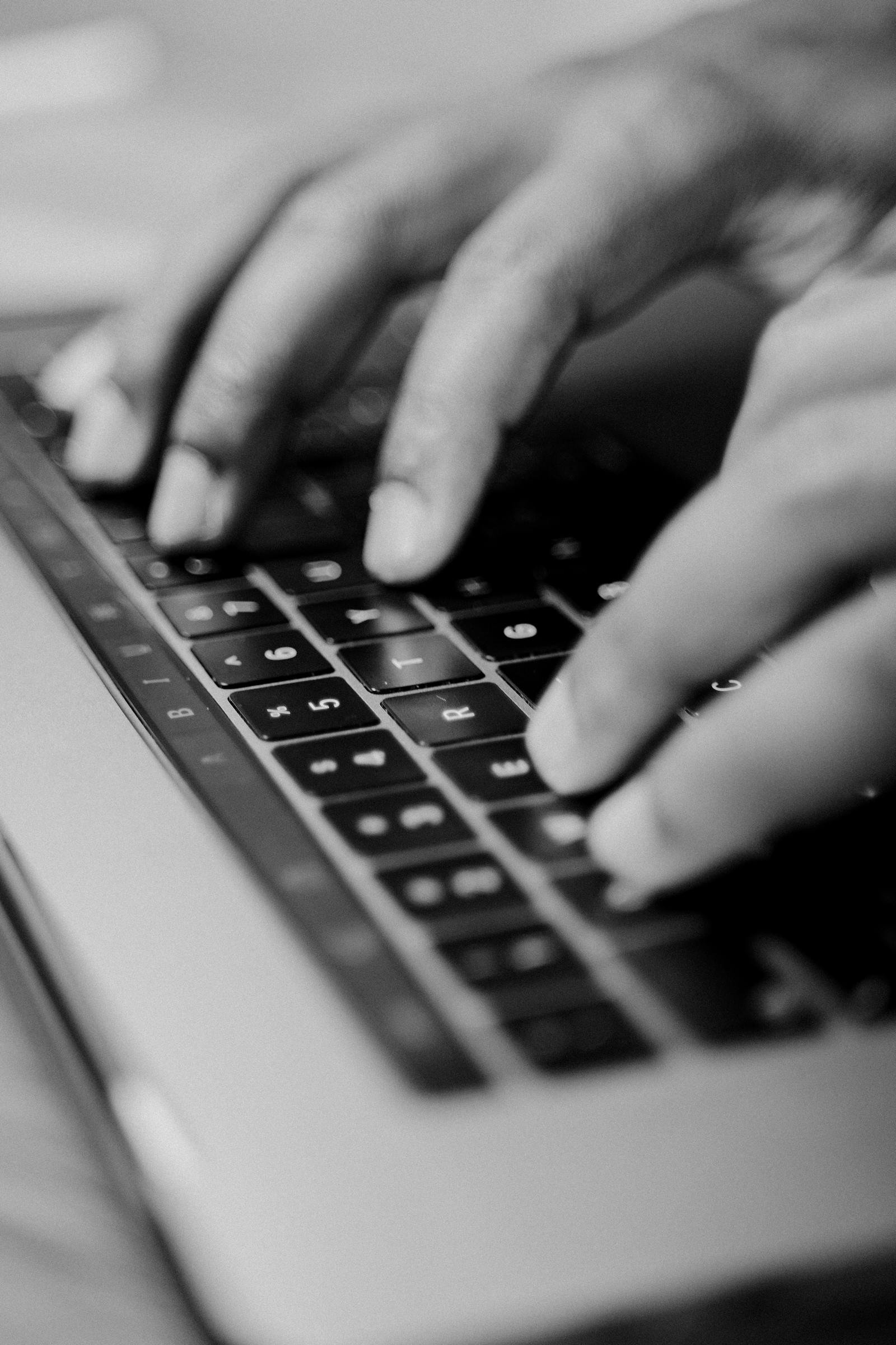 Black and white image of fingers typing on a keyboard illustrating How to Write Emails People Open (2026 Guide)