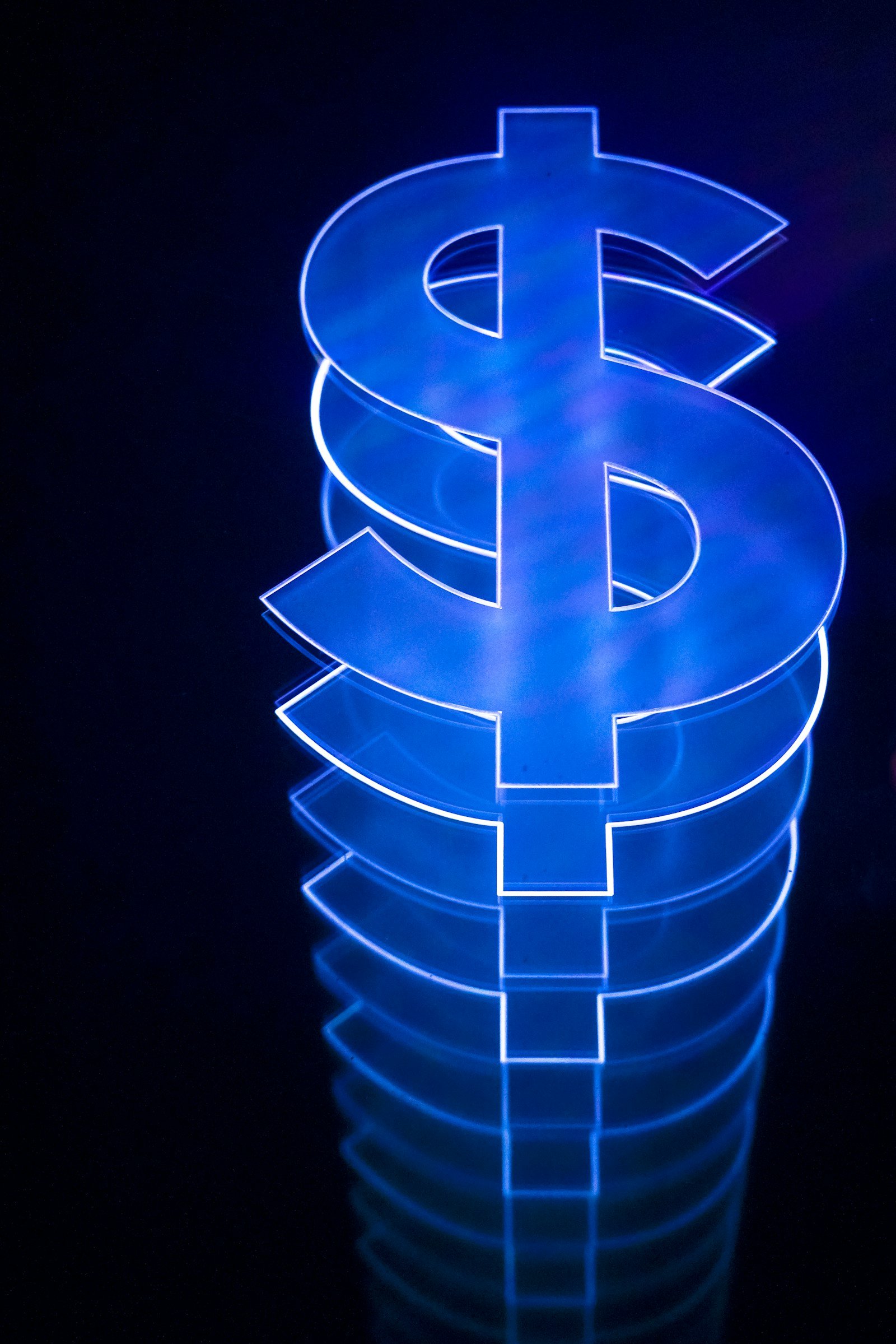Illuminated dollar sign stacked on a dark table illustrating How to Price Freelance Services With a Day Job