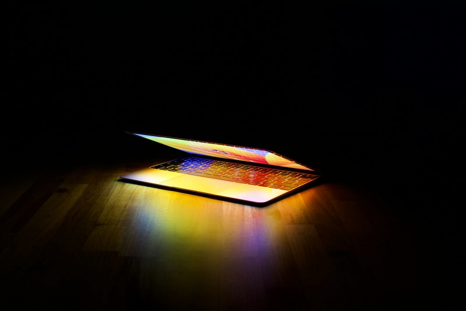 MacBook radiating vivid colored light in a dark room illustrating Notion Review 2026: The Creator Brain Everyone Swears By