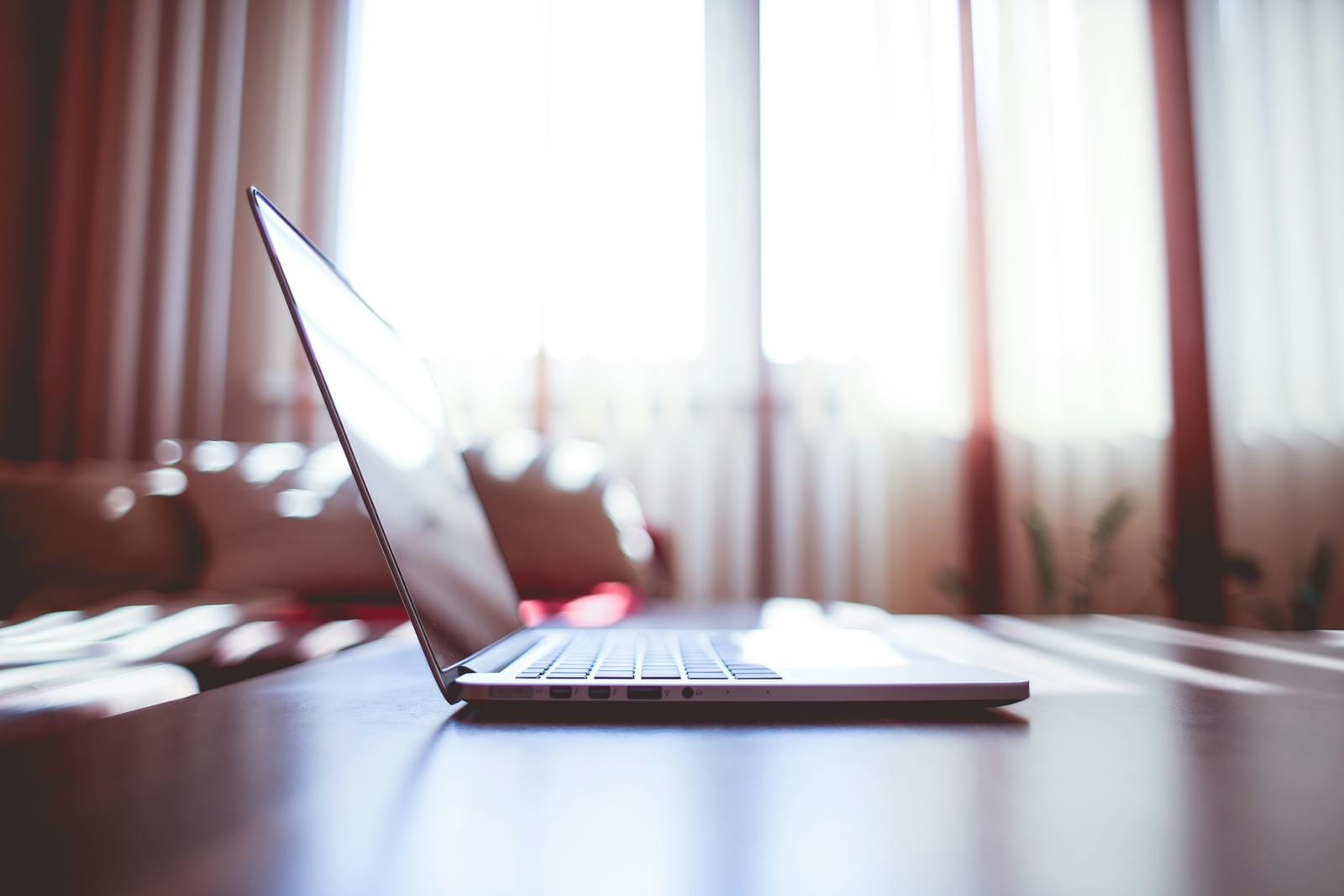 Modern laptop on table illuminated by soft natural light from windows