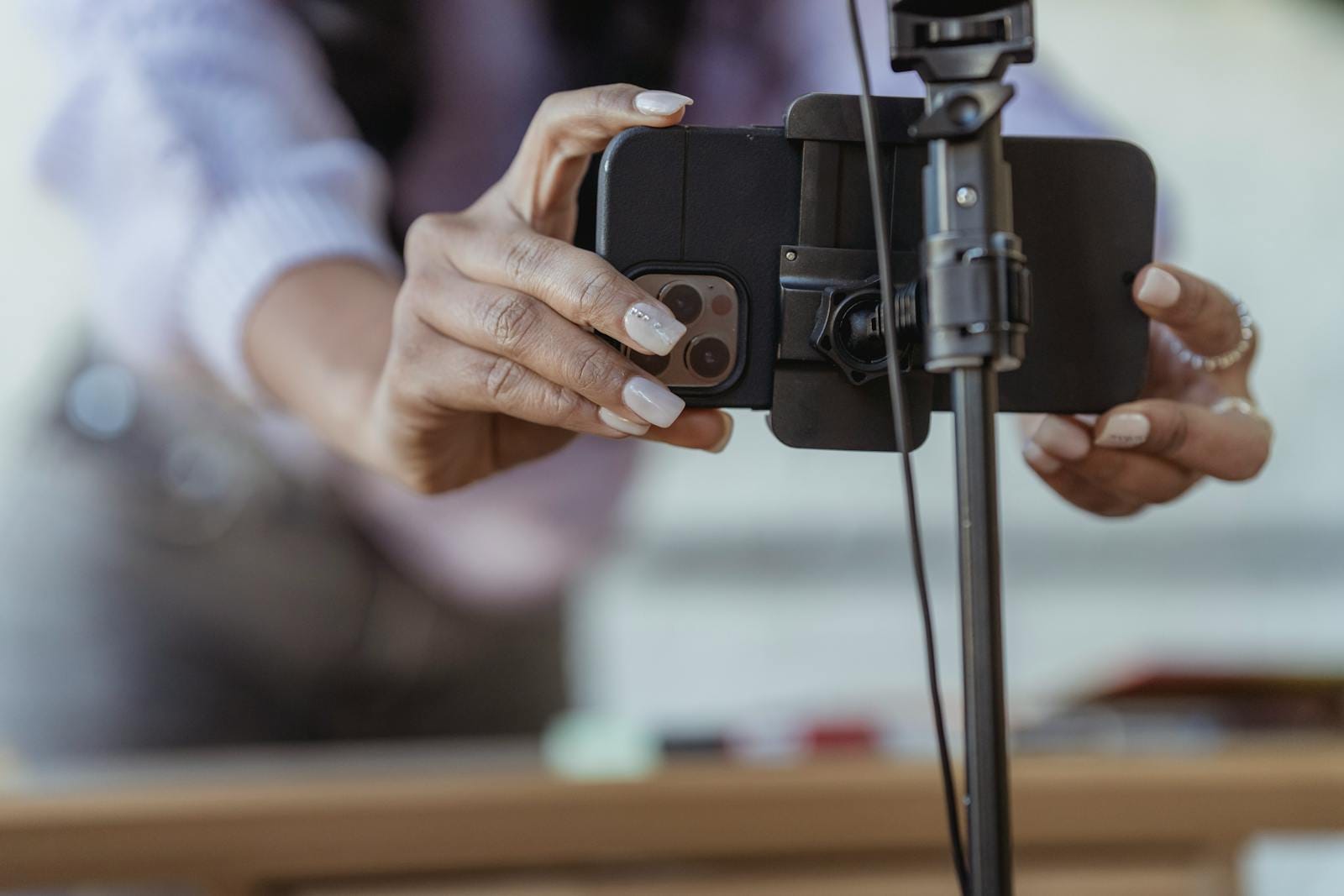 Female setting mobile phone on tripod while recording vlog content