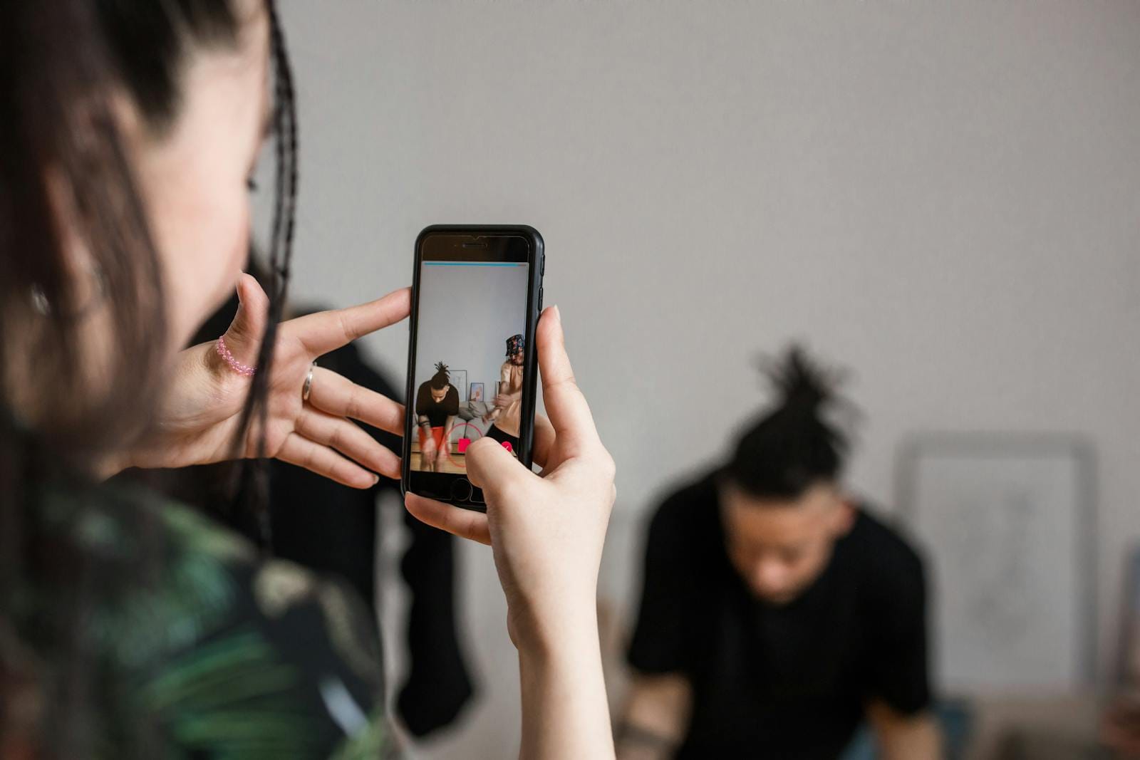 Person recording video with smartphone, illustrating creator content production