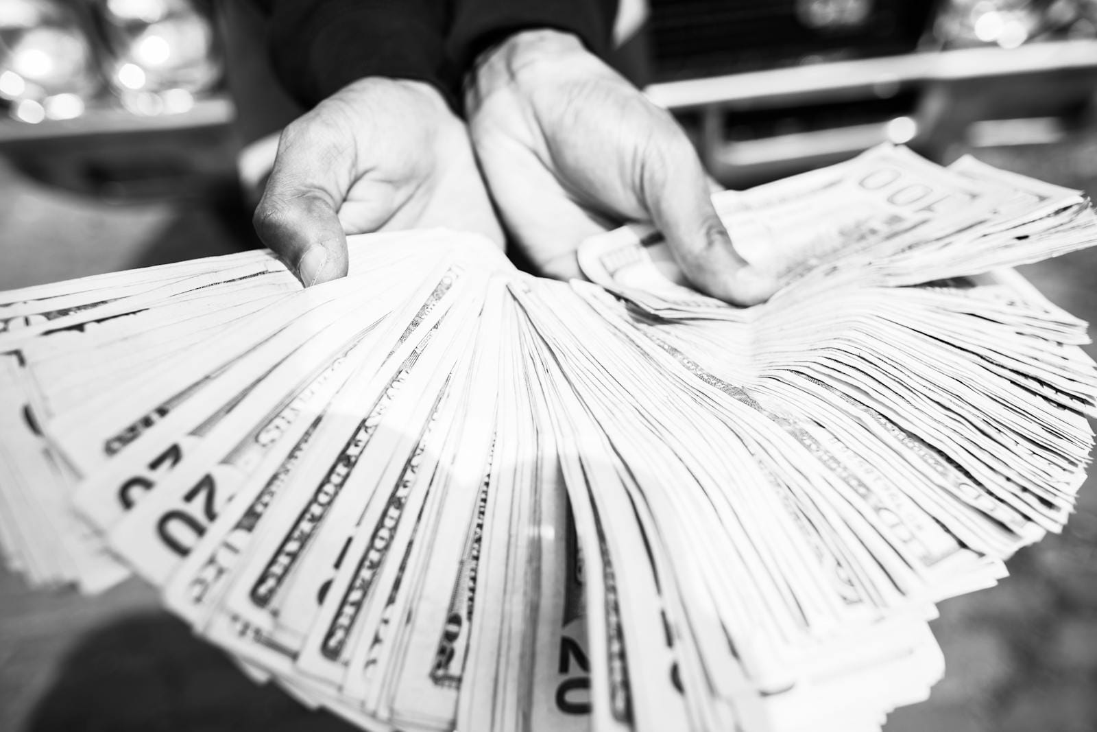 Hands holding cash, black and white finance concept