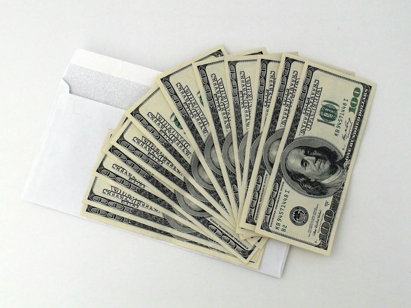 Fan of $100 bills partially out of envelope, illustrating side income