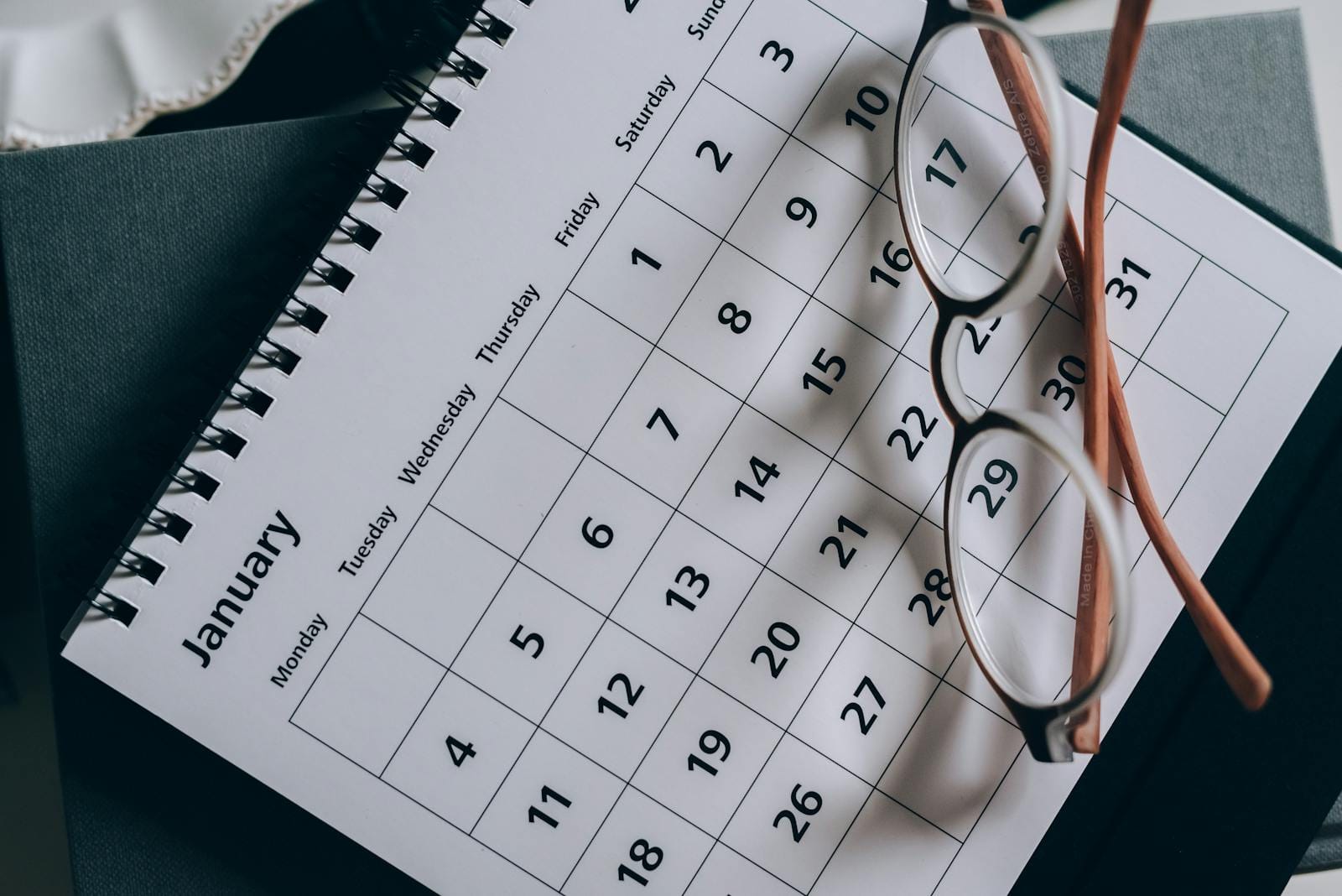 Calendar with eyeglasses on table, illustrating planning and organization