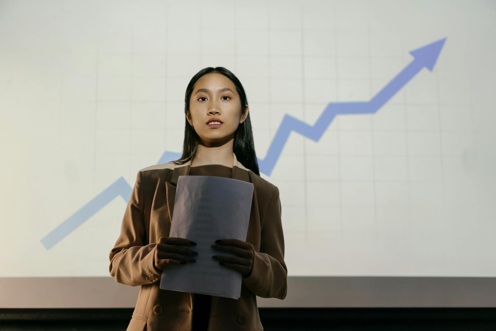 Confident businesswoman presenting growth chart in professional setting