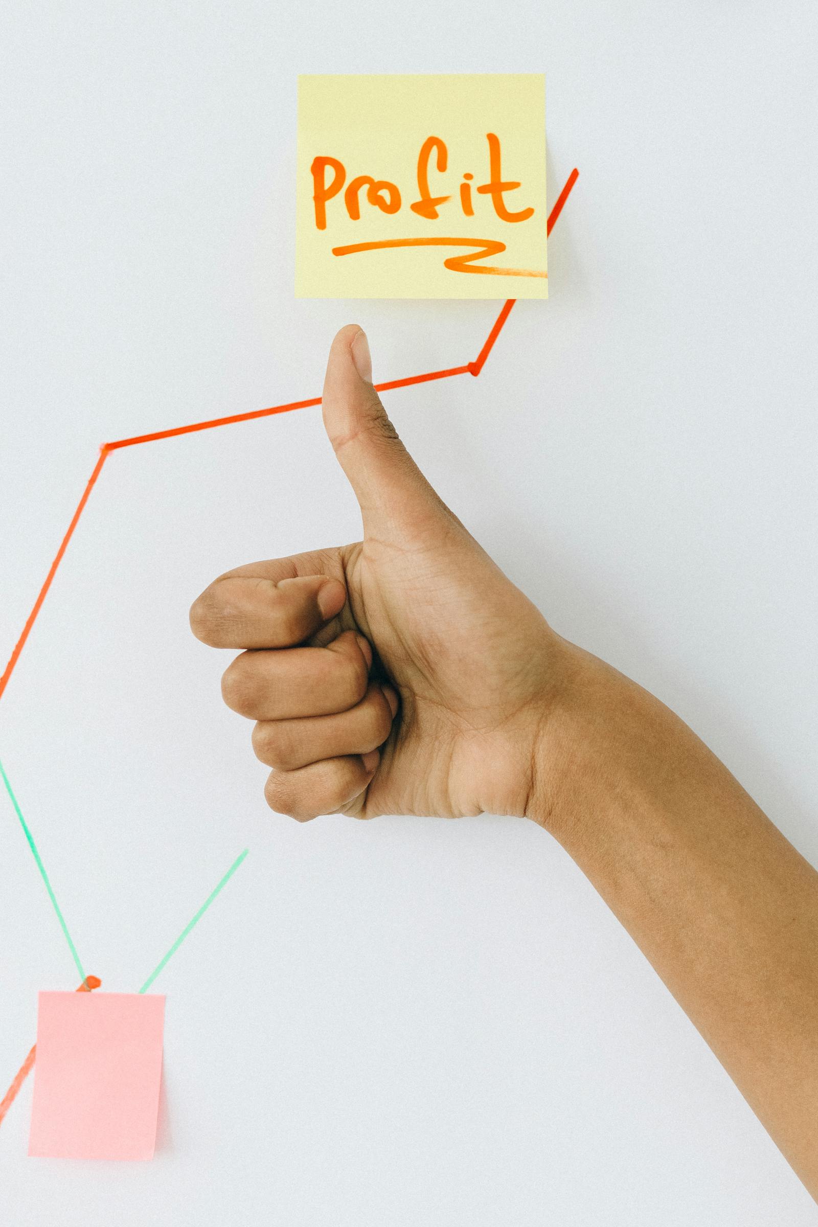 Hand giving thumbs up in front of profit growth chart, illustrating success