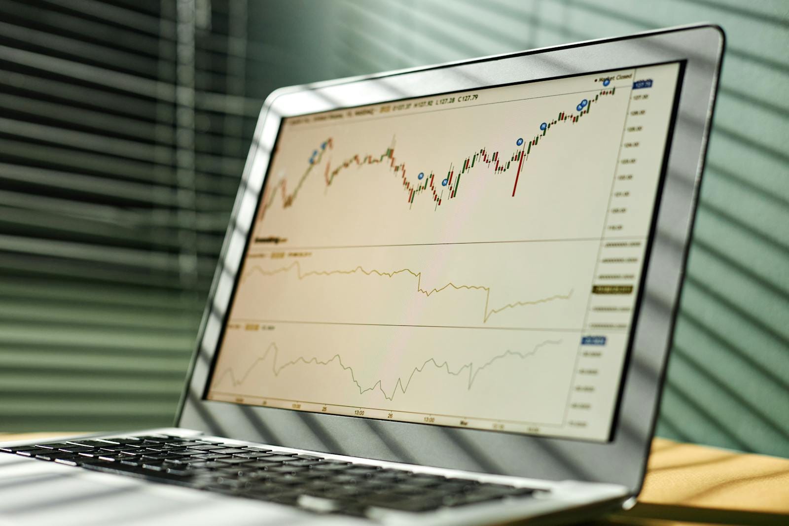 Laptop displaying stock market data and graphs in office