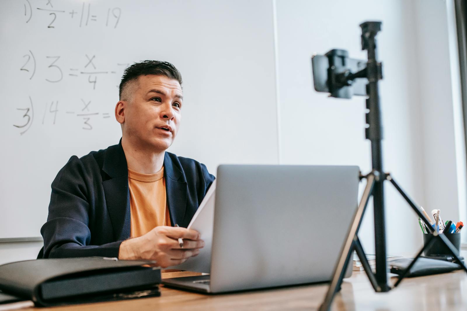 Male instructor conducting online education session with laptop and camera
