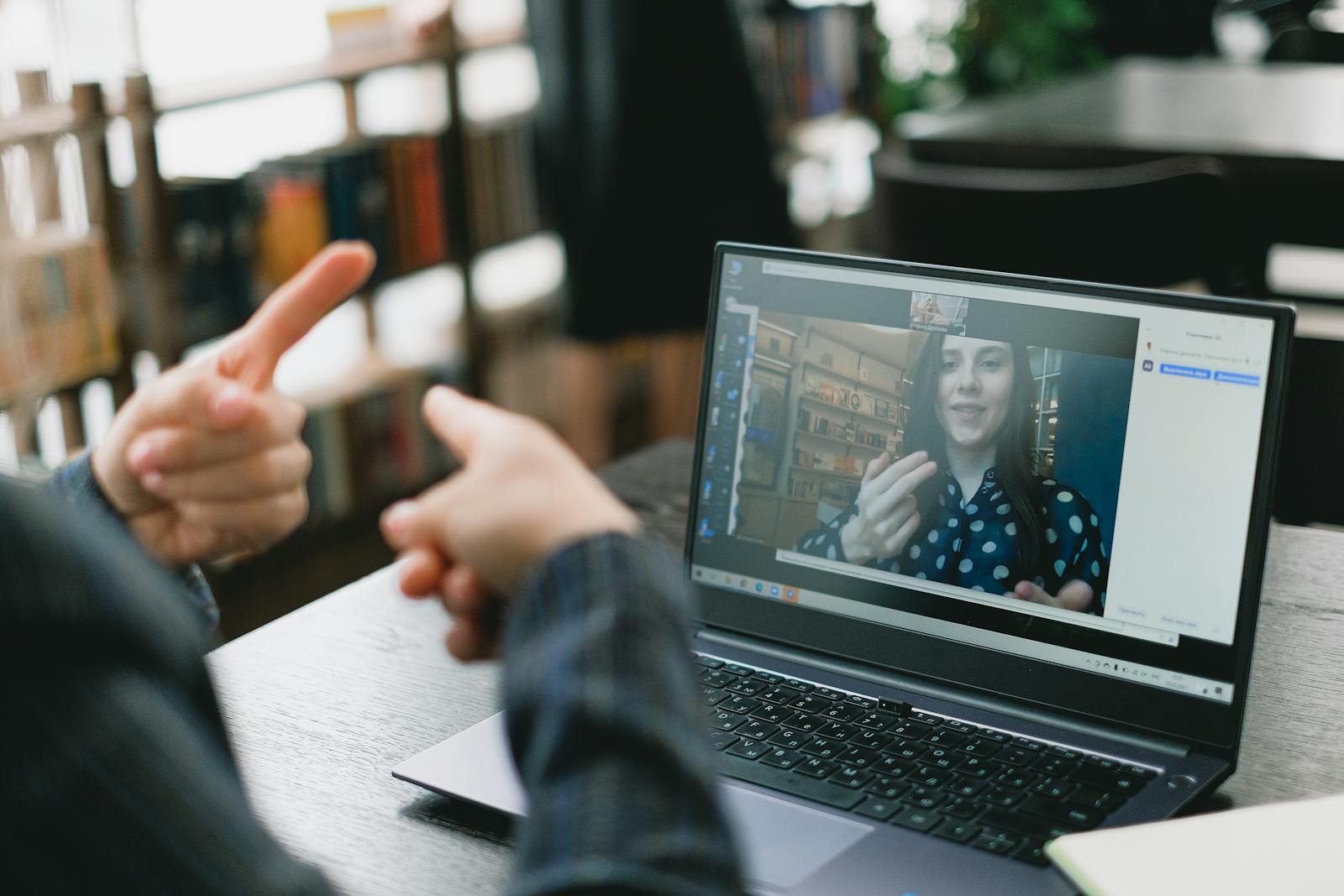 Woman teaching via laptop in light workspace, illustrating online education