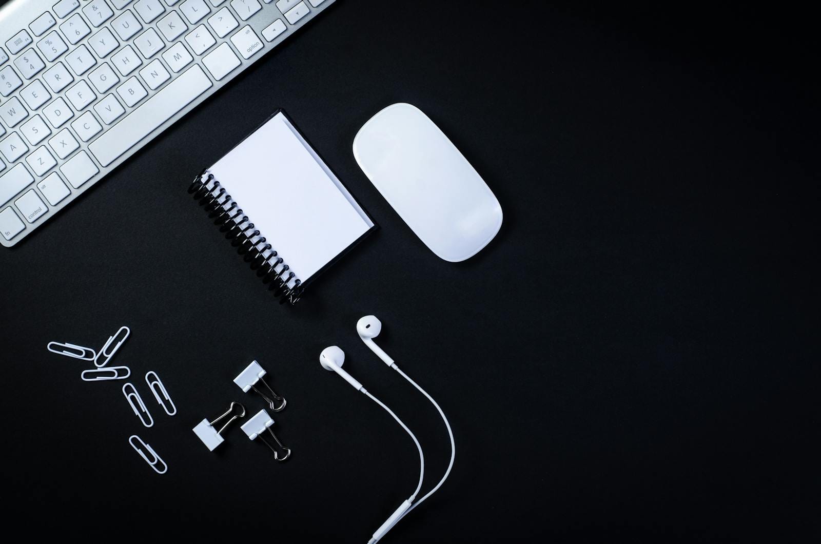 Top view of minimalist office desk with keyboard, mouse, notebook