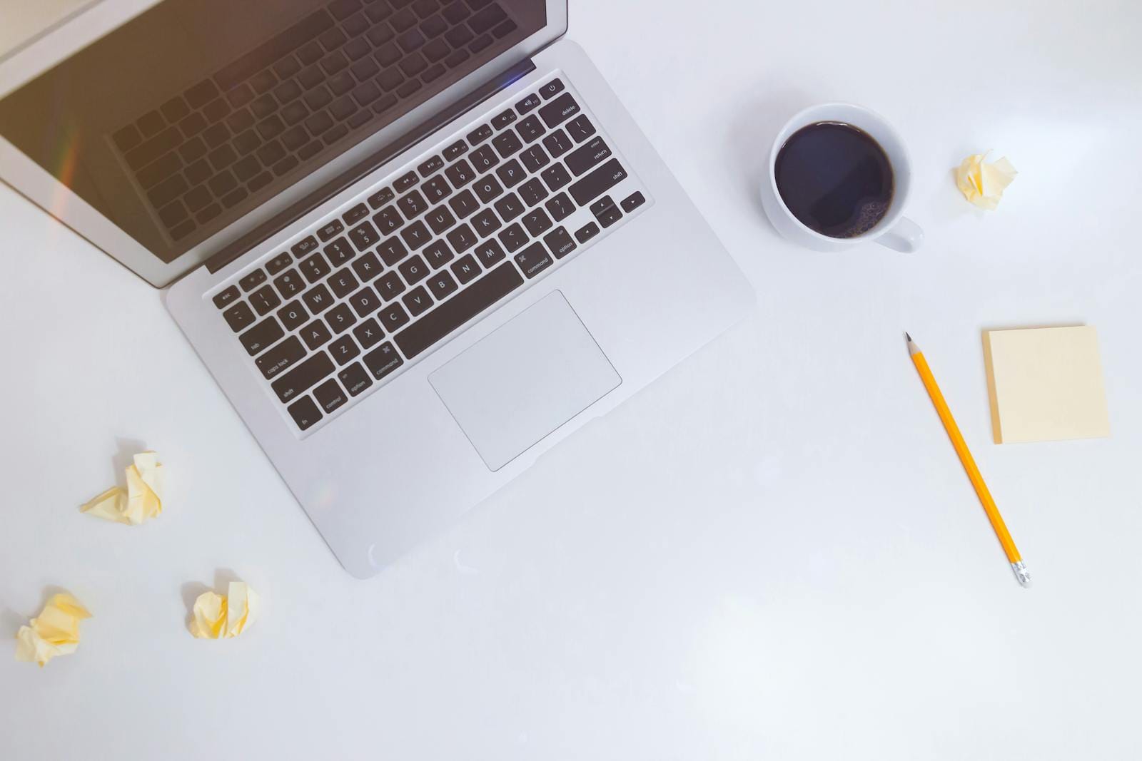 Top view minimalist workspace with laptop, coffee, pencil and crumpled paper