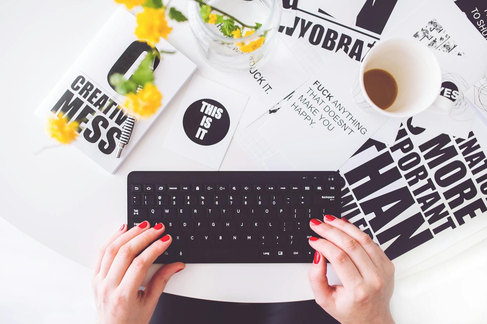 Creative workspace with woman typing surrounded by inspirational typography