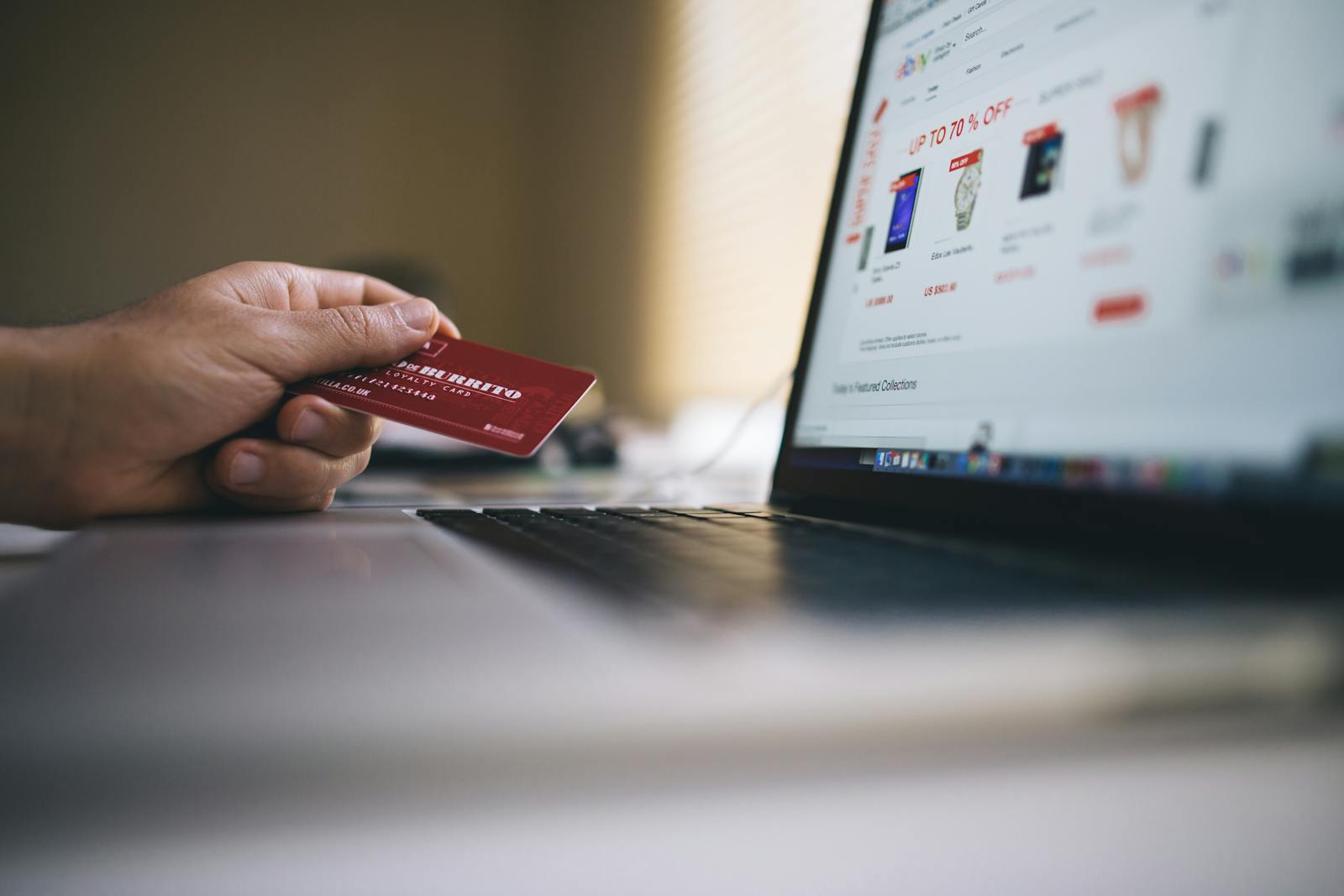 Person with credit card shopping online on laptop, illustrating ecommerce