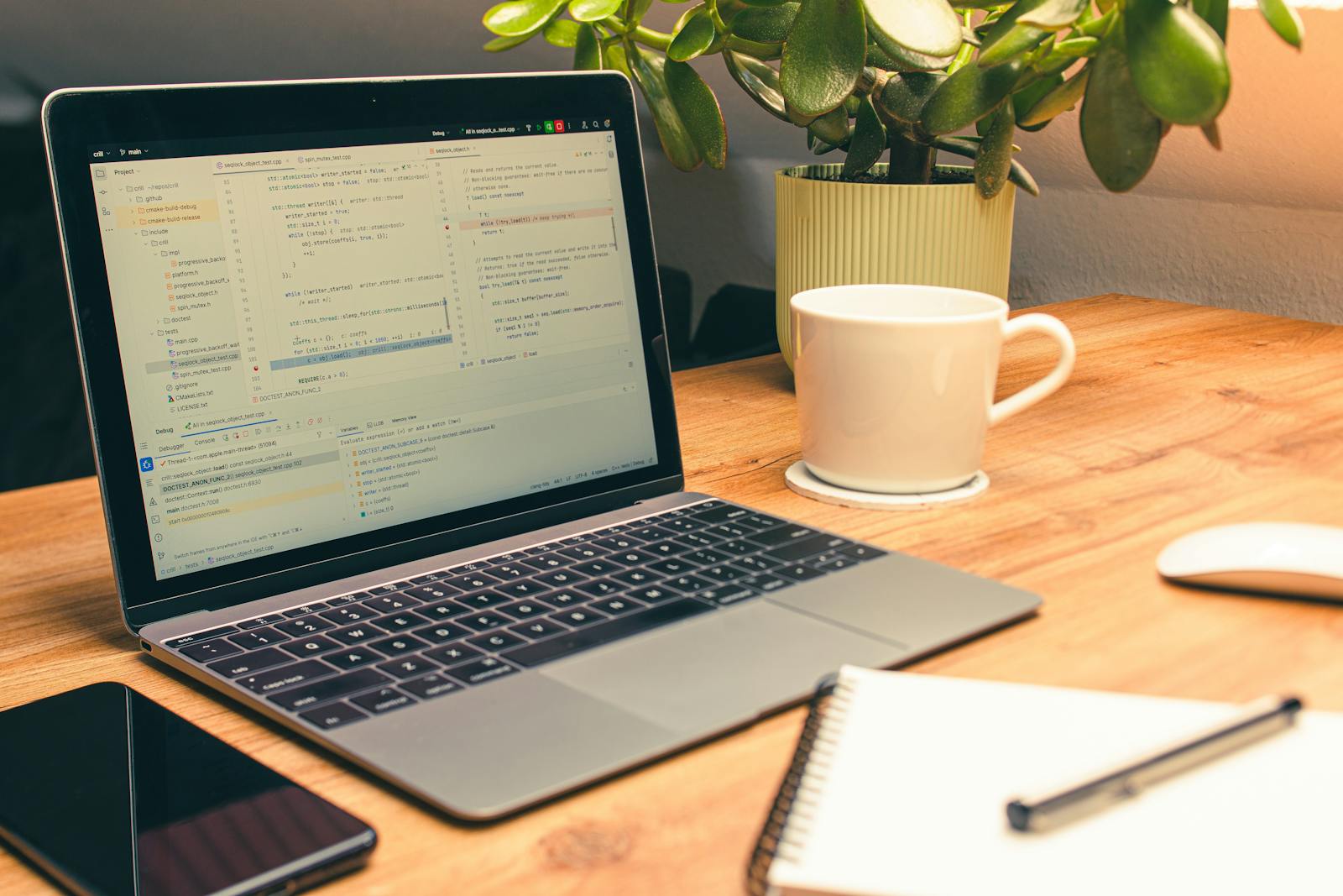Cozy home office with laptop, coffee, and green plant, illustrating ongoing creator workflow