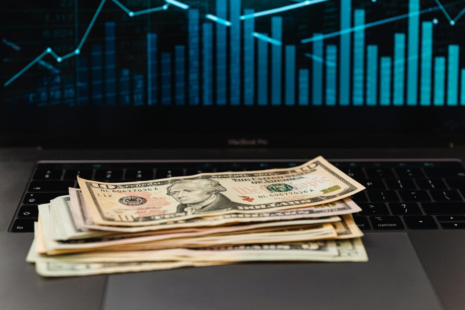 Dollar bills on laptop with chart, illustrating AffSense CPA network