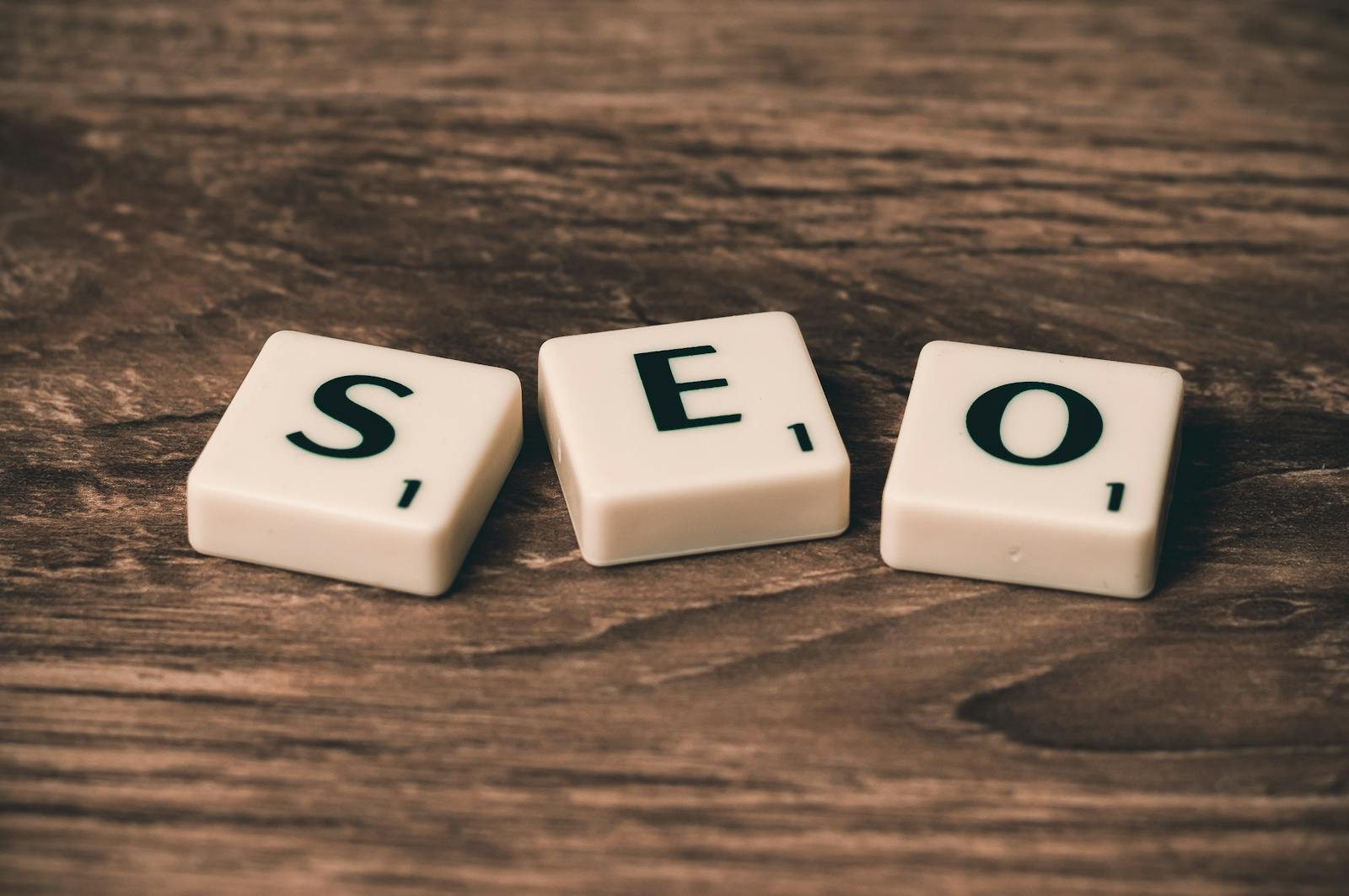 Scrabble tiles spelling SEO on wooden surface, illustrating search engine optimization basics
