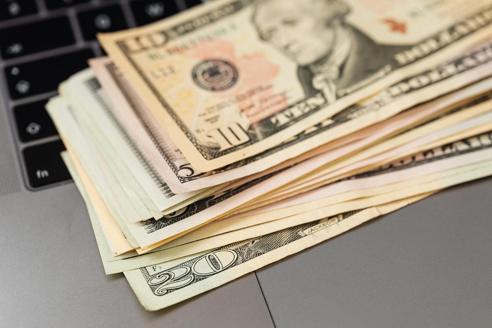 Stack of US dollar bills on a keyboard, illustrating digital savings