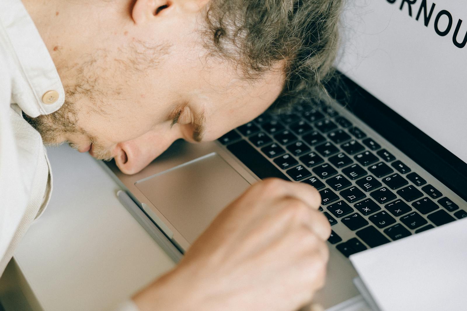 Exhausted creator face-down on laptop keyboard, illustrating creator burnout